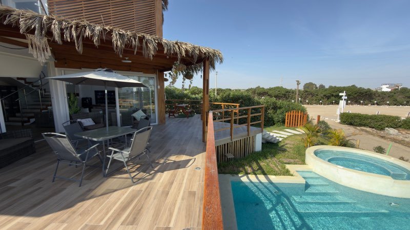 Terraza con deck de madera, parrilla y piscina frente al mar de Chincha